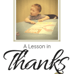 A little boy with strawberry blond hair sitting at a table giving thanks