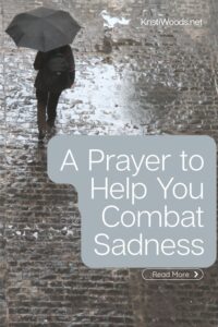 person walking on a brick street in the rain, holding an umbrella over their head